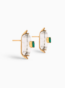 Aretes pequeños con esmeralda en bruto y cuarzo, una combinación perfecta de modernidad y elegancia. Hechos a mano en bronce con baño de oro de 24K, su diseño geométrico y sofisticado los convierte en el complemento ideal para cualquier ocasión.