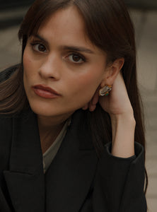 Aretes pequeños con esmeralda en bruto y cuarzo, una combinación perfecta de modernidad y elegancia. Hechos a mano en bronce con baño de oro de 24K, su diseño geométrico y sofisticado los convierte en el complemento ideal para cualquier ocasión.