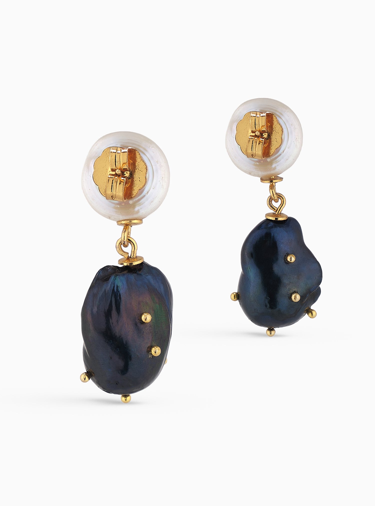 Perla barroca negra con puntos dorados y esmeralda colombiana. Un diseño artesanal contemporáneo y lleno de carácter.
