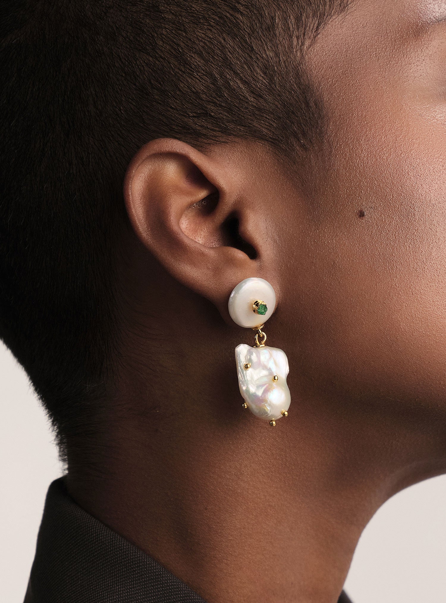 Aretes colombianos de lujo con perla natural y esmeralda cruda. Diseño artesanal en bronce con baño de oro de 24k, hechos en Colombia.