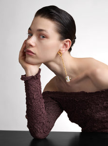 Aretes asimétricos hechos a mano en bronce con baño de oro. Un diseño vanguardista con esmeraldas en bruto y cuarzo