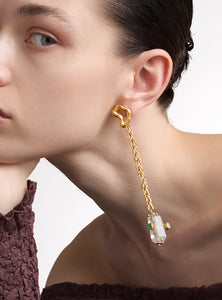 Aretes asimétricos hechos a mano en bronce con baño de oro. Un diseño vanguardista con esmeraldas en bruto y cuarzo