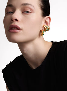 Aretes tipo candonga con un diseño escultural único, elaborados en bronce con baño de oro de 24K y engaste de esmeraldas en bruto. Una pieza artesanal perfecta para destacar con elegancia y autenticidad. ¡Descúbrelos!