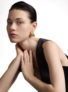 Aretes esculturales con esmeraldas naturales incrustadas, inspirados en formas orgánicas de la región de Muzo Boyacá. Elaborados a mano en bronce con baño de oro de 24K, fusionan elegancia y diseño contemporáneo.