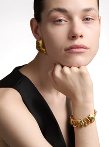 Pulsera artesanal con eslabones de bronce bañados en oro de 24K y detalles de esmeralda en bruto. Su diseño orgánico y escultural lo convierte en una pieza statement única, perfecta para quienes buscan joyas sofisticadas y atemporales.