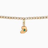 Charm artesanal con esmeralda en bruto incrustada y baño de oro de 24k. Un diseño orgánico y elegante que celebra la belleza natural de la piedra.