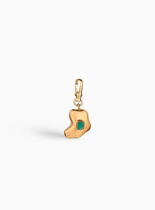 Charm artesanal con esmeralda en bruto incrustada y baño de oro de 24k. Un diseño orgánico y elegante que celebra la belleza natural de la piedra.