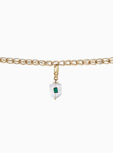Elegante charm de cuarzo blanco con esmeraldas en bruto y baño de oro de 24k. Un diseño atemporal y artesanal que resalta la belleza natural de las piedras.