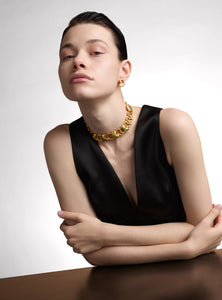 Collar artesanal con eslabones de bronce bañados en oro de 24K y detalles de esmeralda en bruto. Su diseño orgánico y escultural lo convierte en una pieza statement única, perfecta para quienes buscan joyas sofisticadas y atemporales.