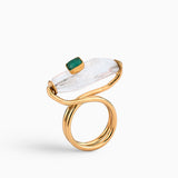 Anillo artesanal con cuarzo y esmeralda en bruto, montado en una estructura dorada de diseño escultural. Hecho a mano en bronce con baño de oro de 24K, ideal para quienes buscan una joya única y sofisticada