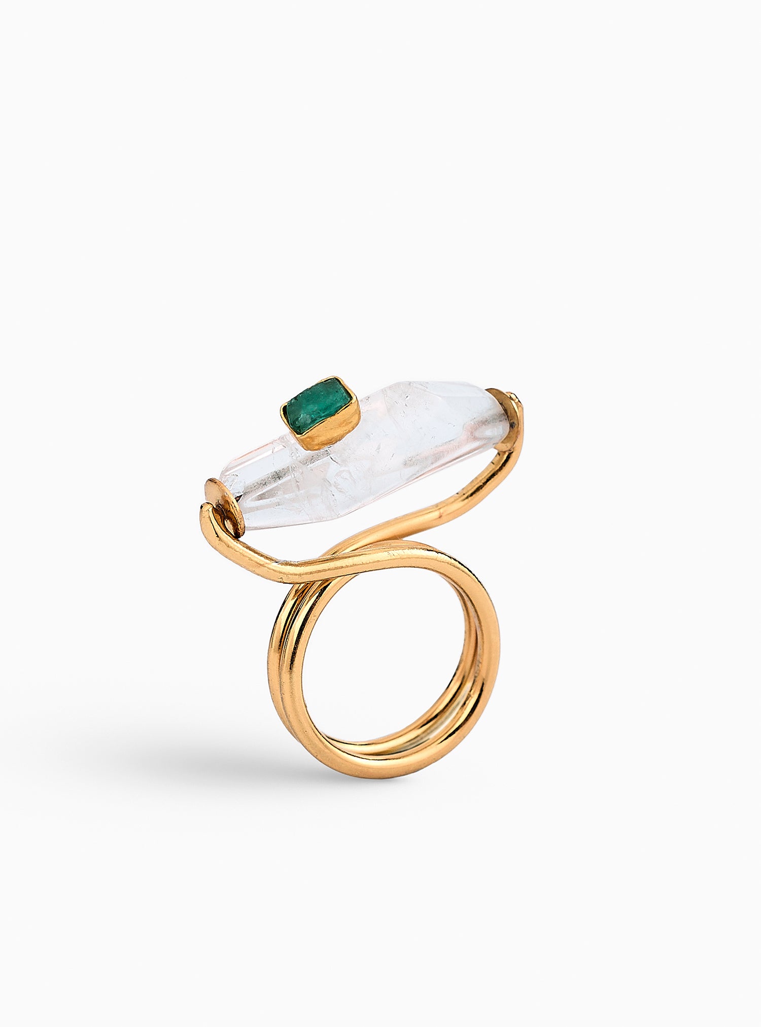 Anillo artesanal con cuarzo y esmeralda en bruto, montado en una estructura dorada de diseño escultural. Hecho a mano en bronce con baño de oro de 24K, ideal para quienes buscan una joya única y sofisticada
