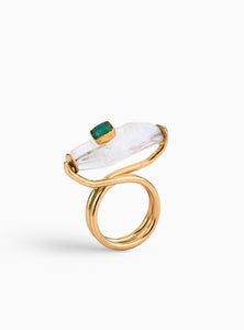 Anillo artesanal con cuarzo y esmeralda en bruto, montado en una estructura dorada de diseño escultural. Hecho a mano en bronce con baño de oro de 24K, ideal para quienes buscan una joya única y sofisticada