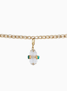 Elegante charm de cuarzo blanco con esmeraldas en bruto y baño de oro de 24k. Un diseño atemporal y artesanal que resalta la belleza natural de las piedras.